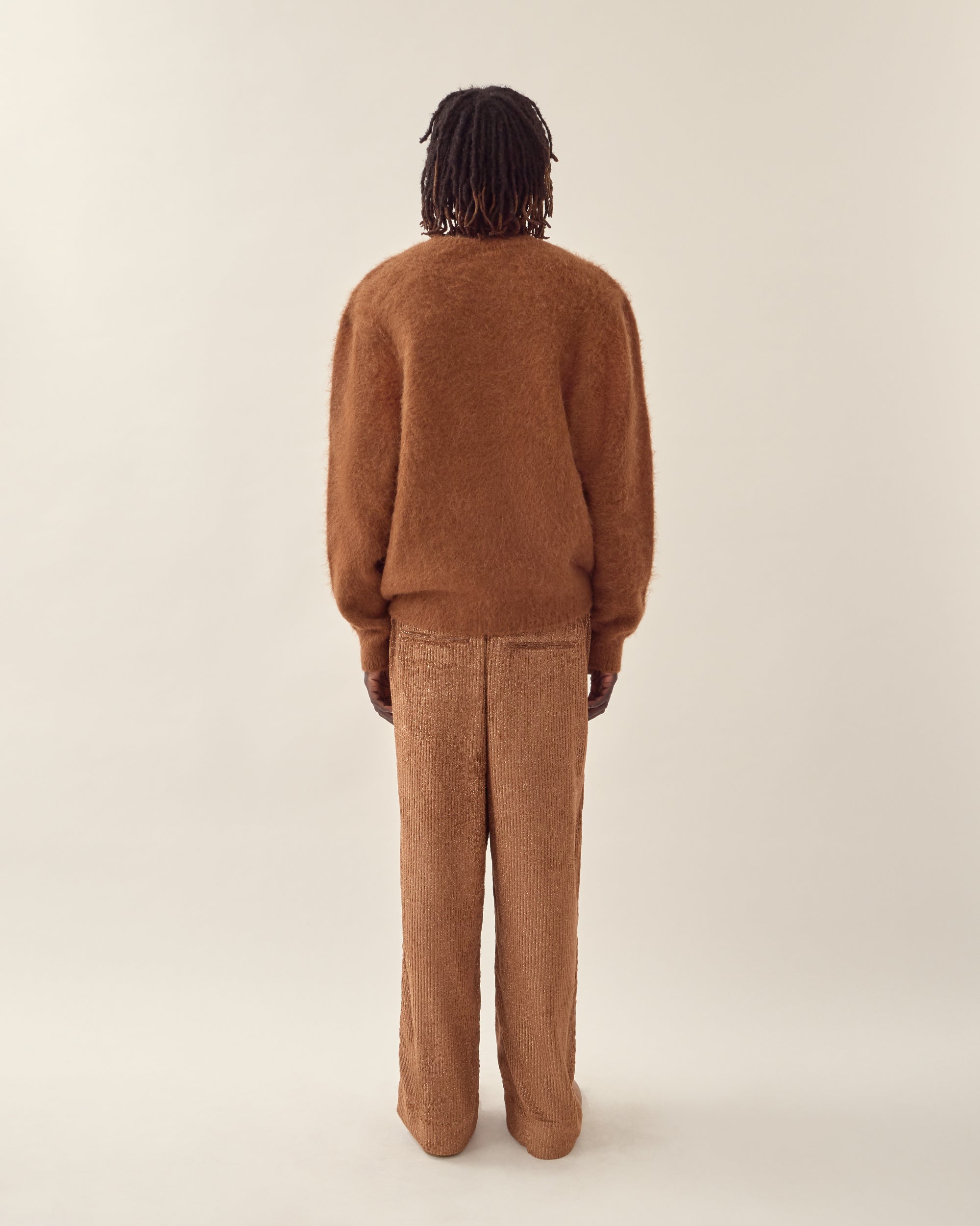 back view of men's burnt orange corduroy trouser in orange.