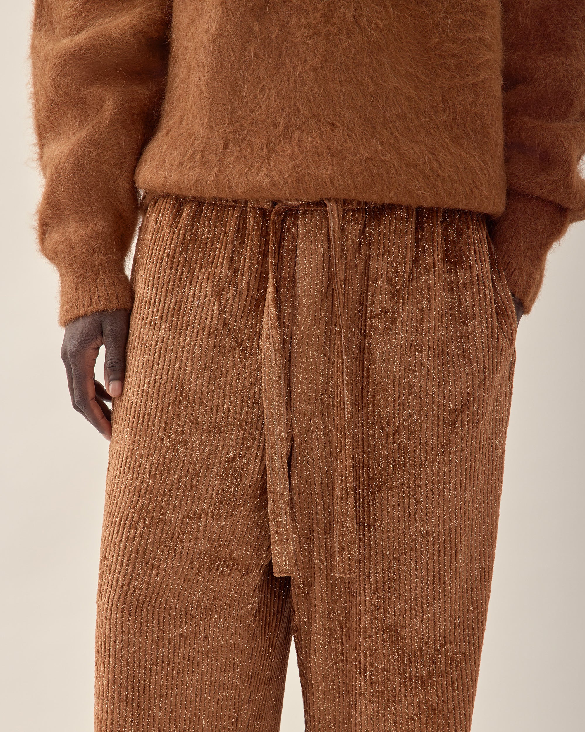close up view of men's burnt orange corduroy trouser in orange.