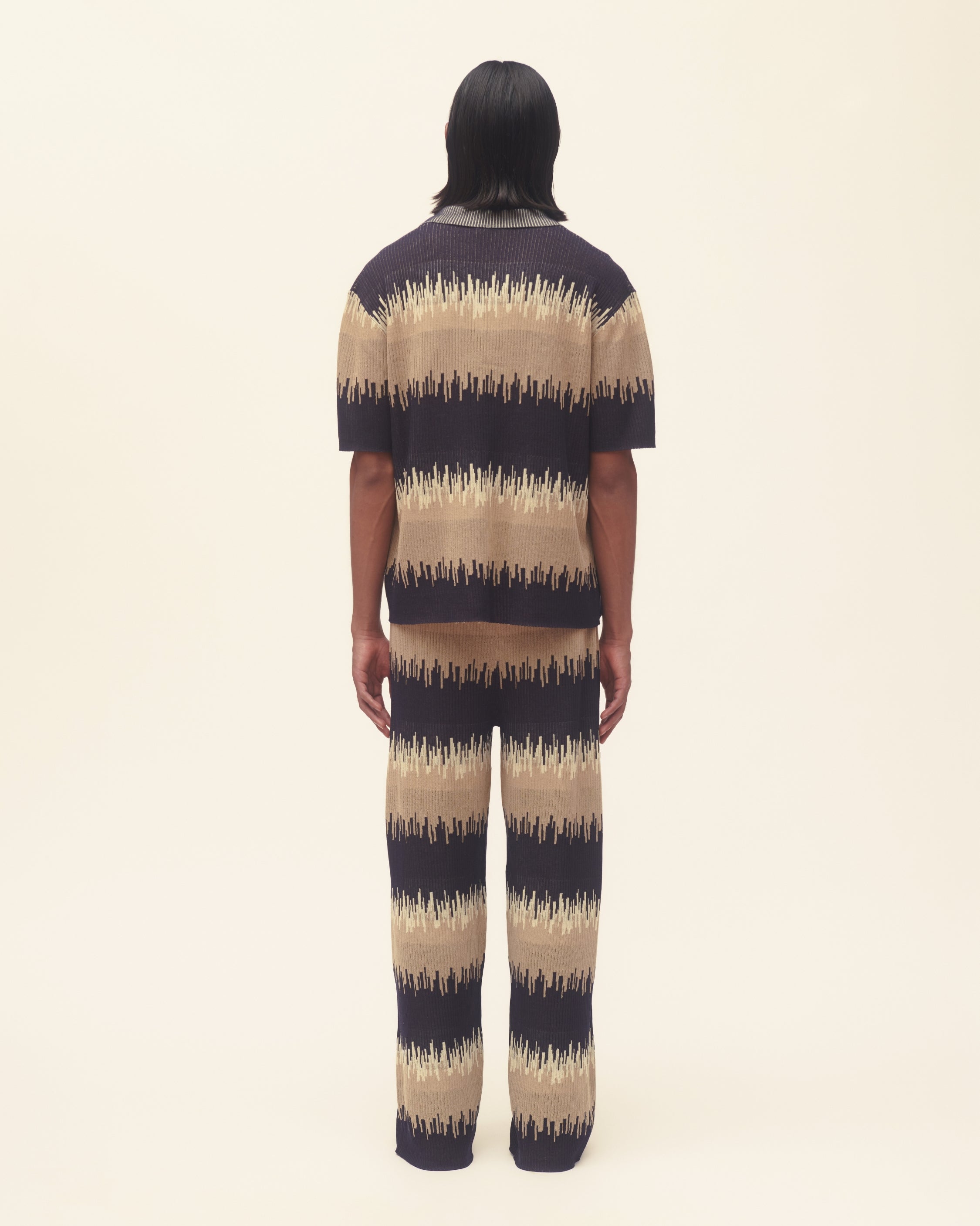 Person wearing a wavy print outfit on a plain background