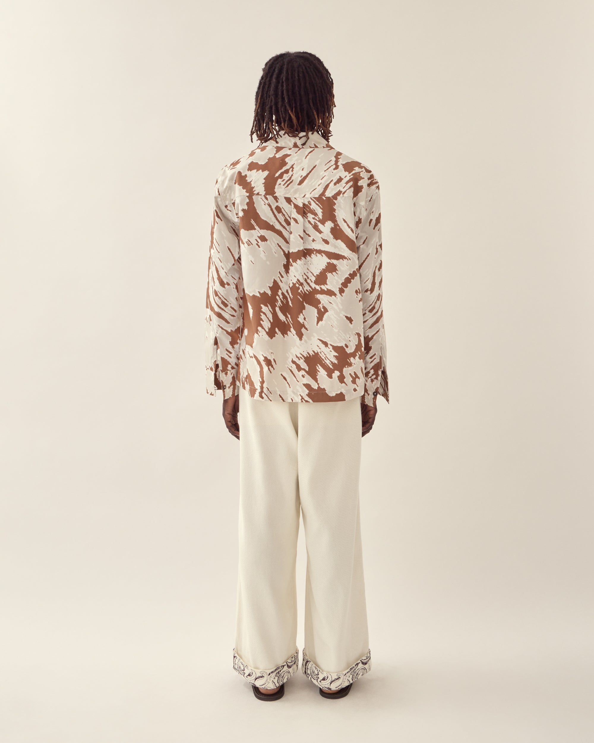 back view of paisley embroidered cuff trouser in cream.