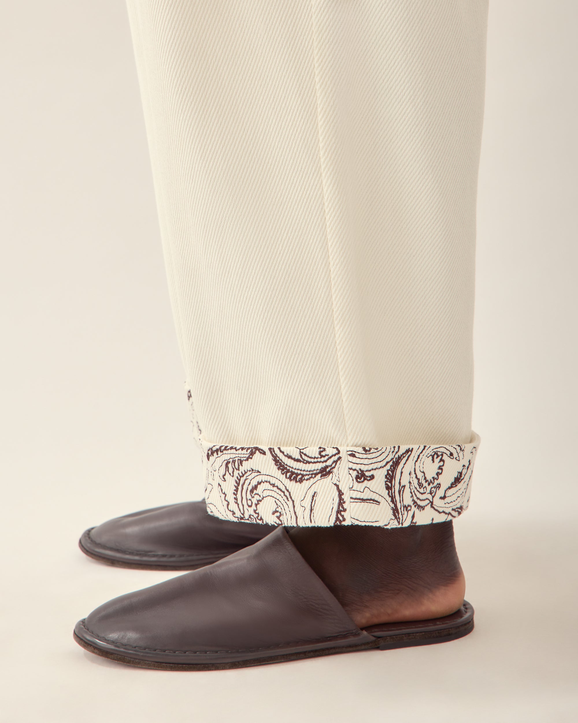 view of cuff detail paisley embroidered cuff trouser in cream.