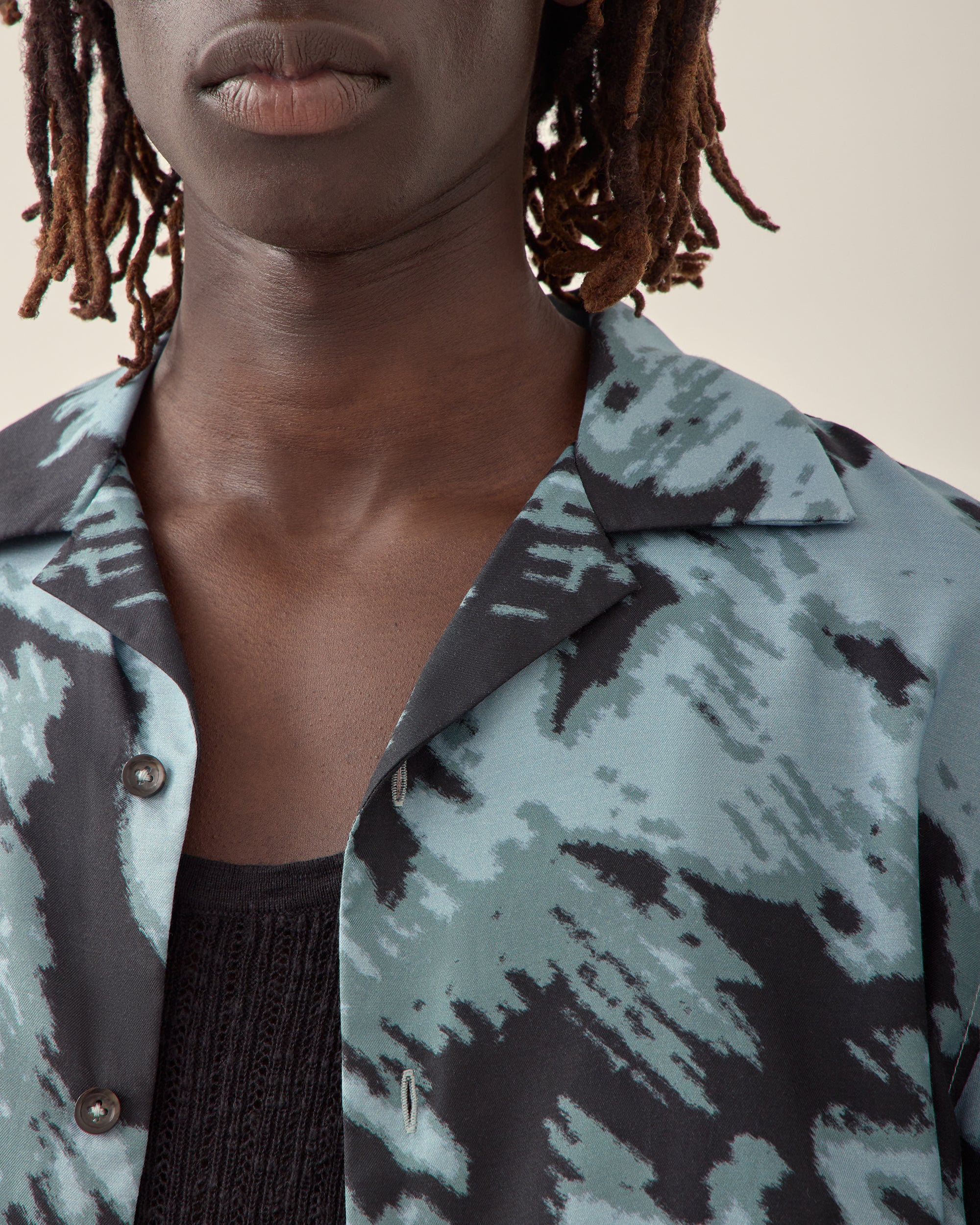 Close view of men's paisley print silk camp collar shirt in navy.