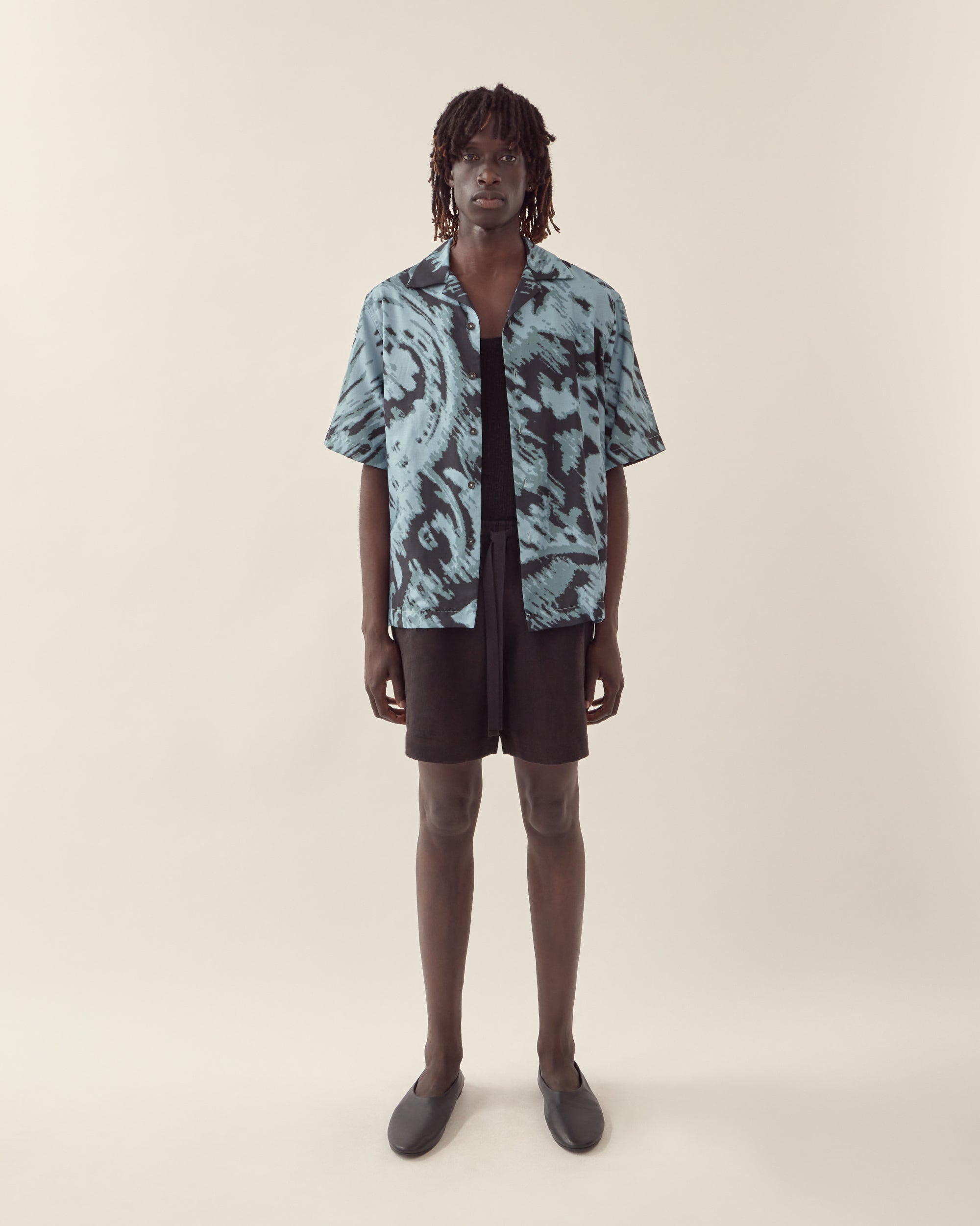 Front view of men's paisley print silk camp collar shirt in navy.