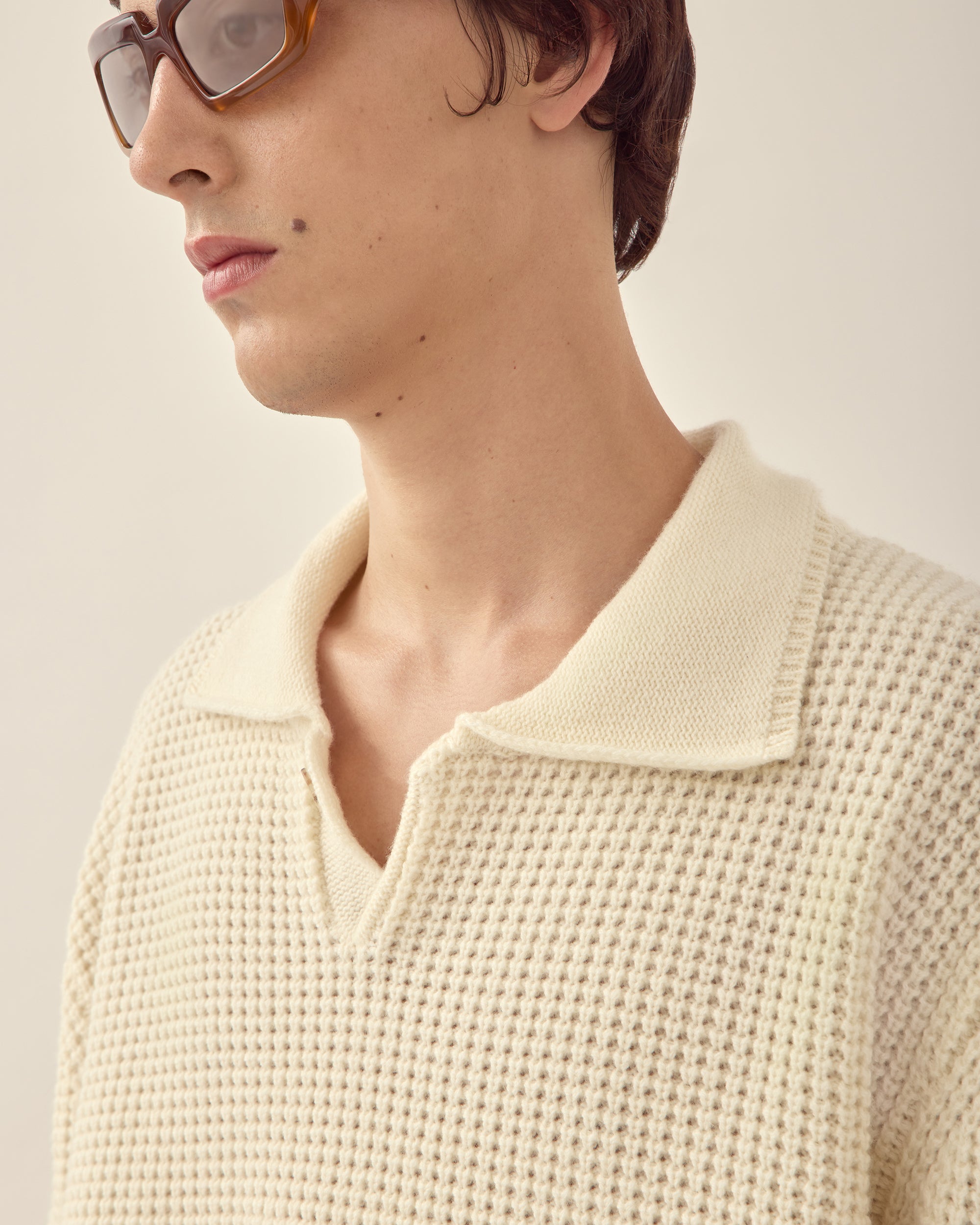 Close view of men's wool cashmere collared sweater in off white.