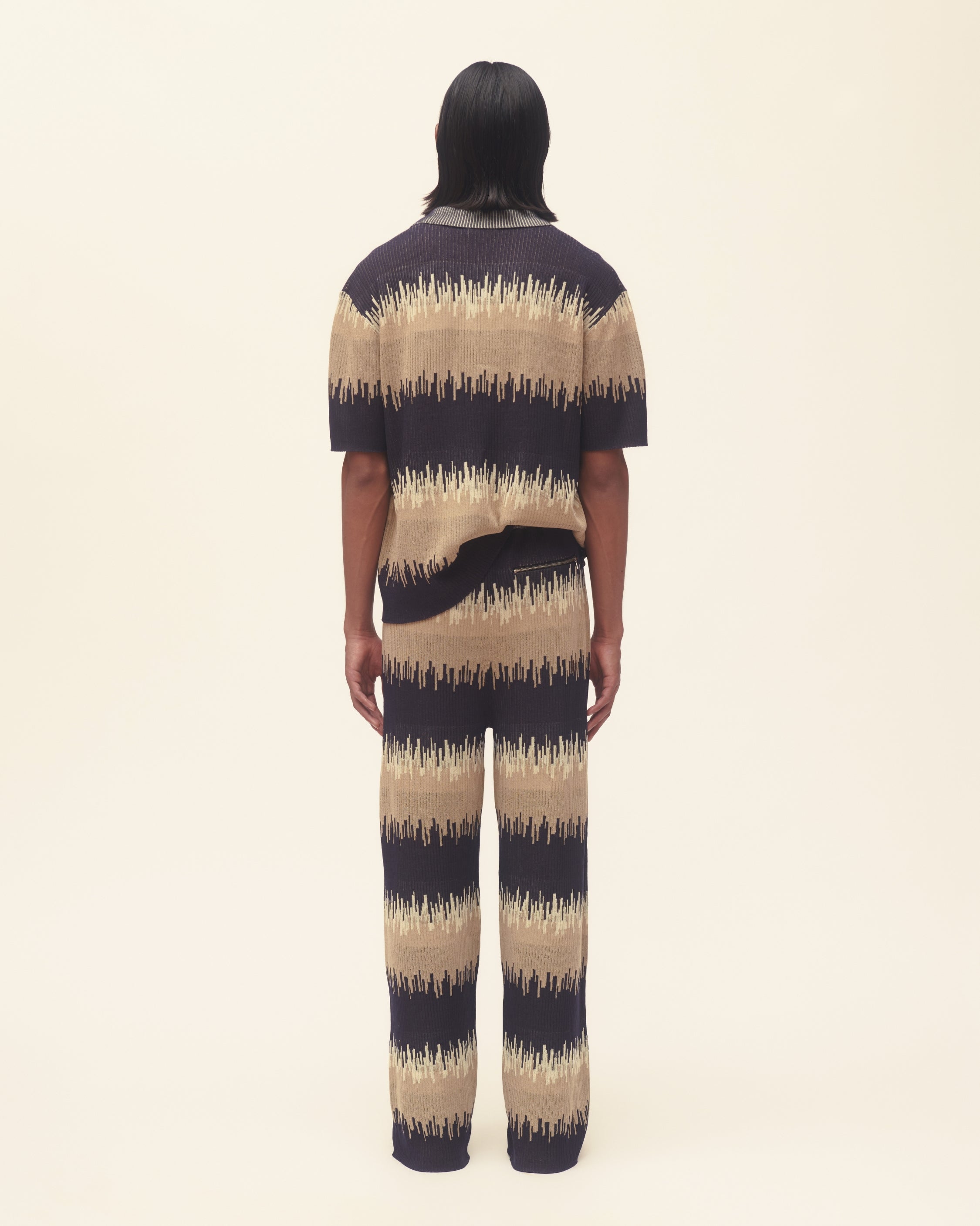 Person wearing a wave print outfit on a plain background