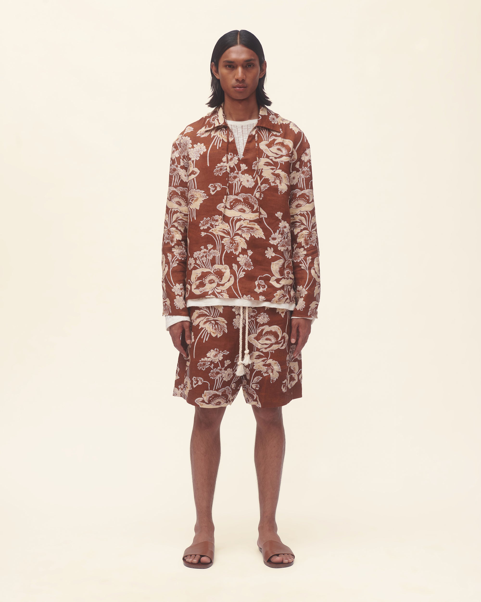 Person wearing a floral patterned outfit on a plain background